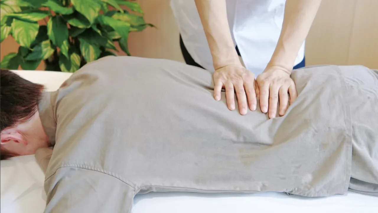 うつ伏せの姿勢で背中から腰まわりを整えている整体の施術